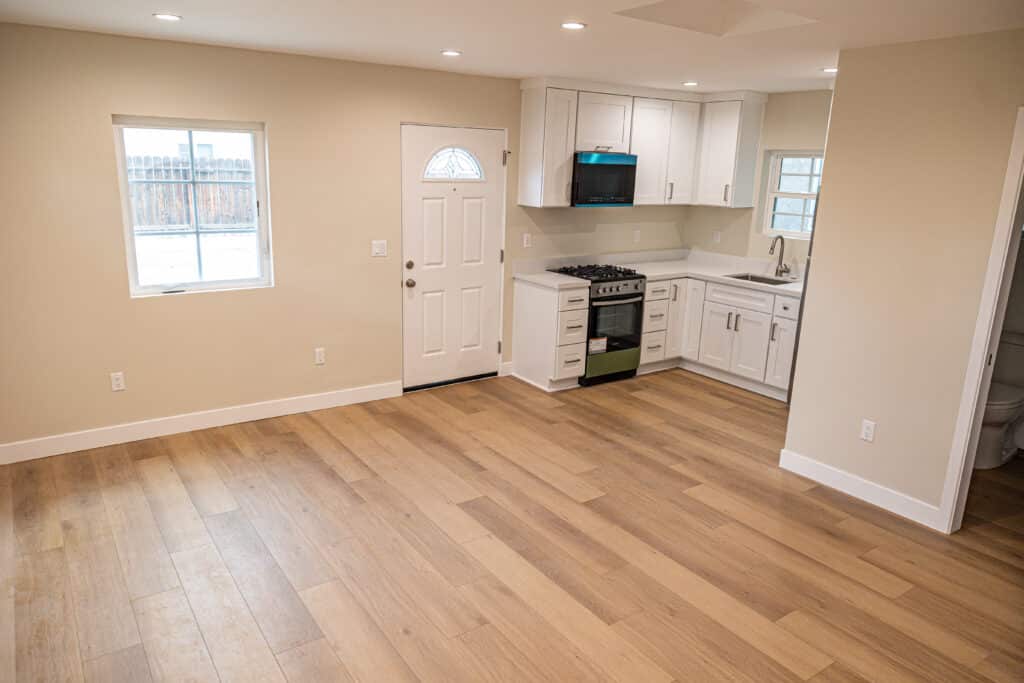 Open-plan ADU interior with a new kitchen, private entrance and wood flooring