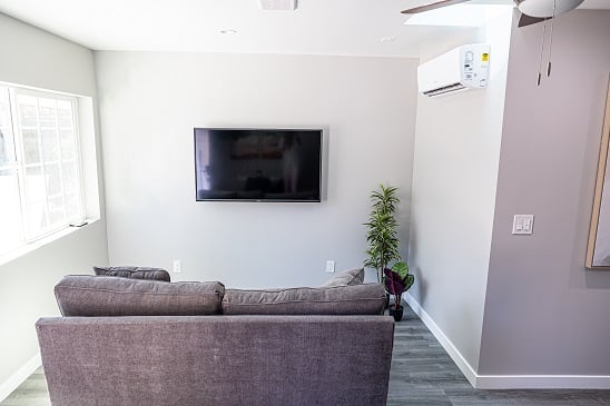 Comfortable finished ADU living room with a mounted TV and a ductless mini-split