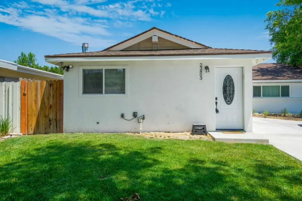 Finished white ADU exterior with a landscaped lawn