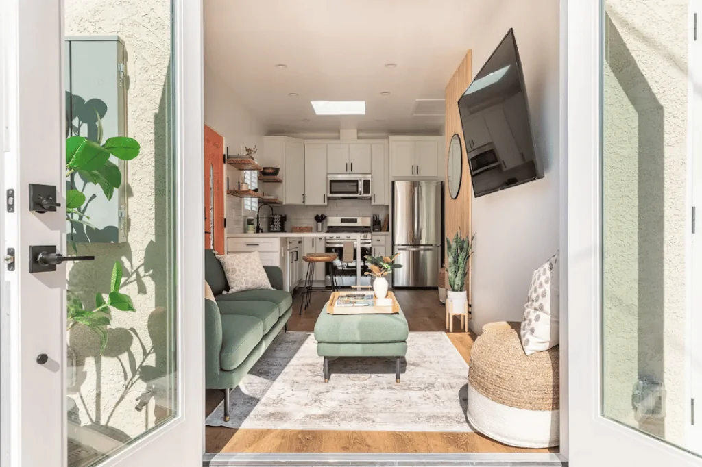 Finished ADU living space with a green sofa and kitchen beyond