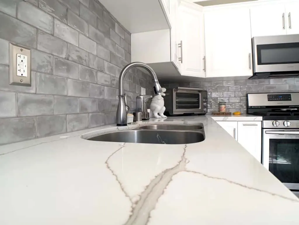 Bright kitchen with a quartz countertop and grey subway-tile backsplash